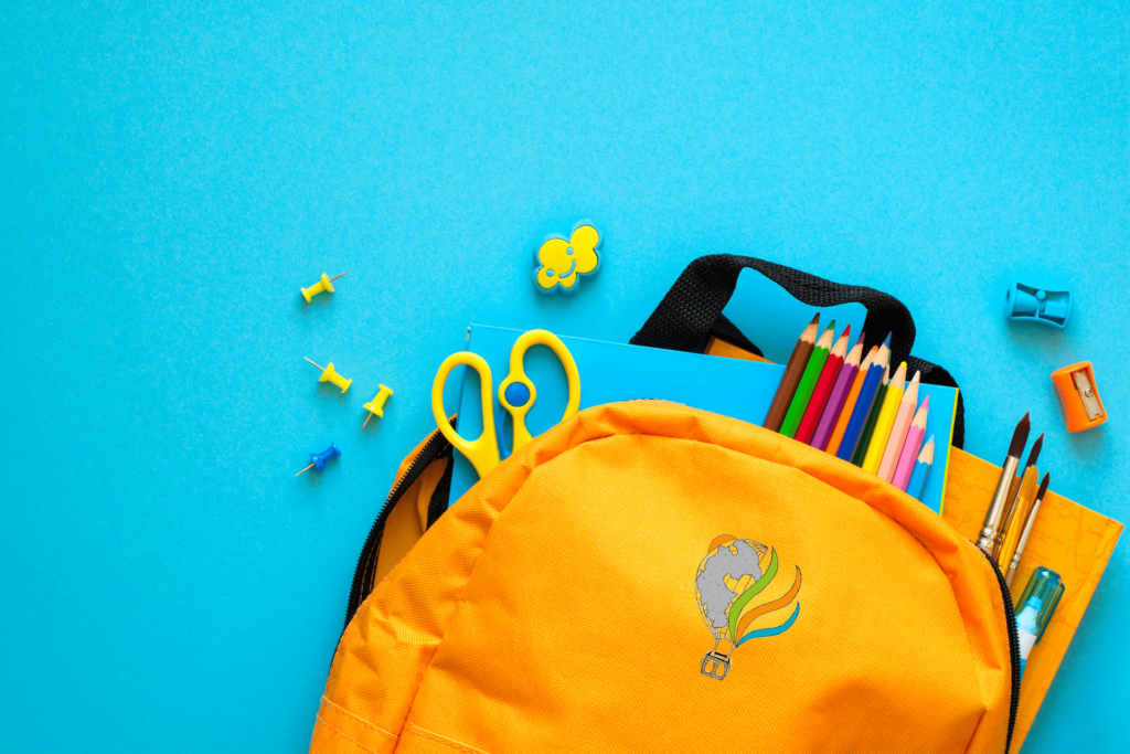 cartable orange avec le logo strat&ci brodé devant, le cartable est ouvert et des fournitures scolaires en sortent