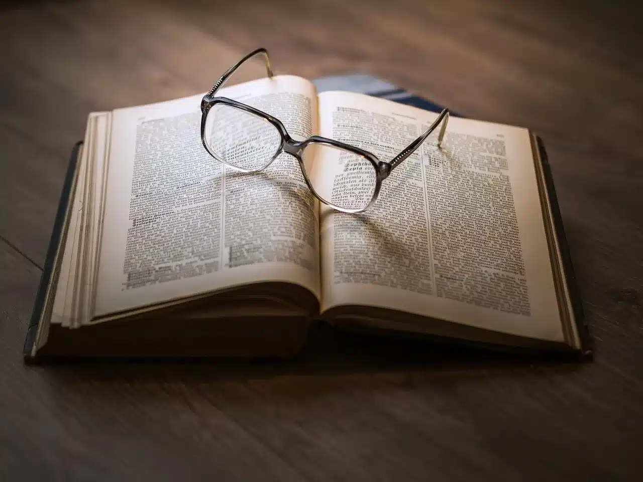 Paire de lunettes sur un livre ouvert illustrant le fait d'actualiser ses connaissances